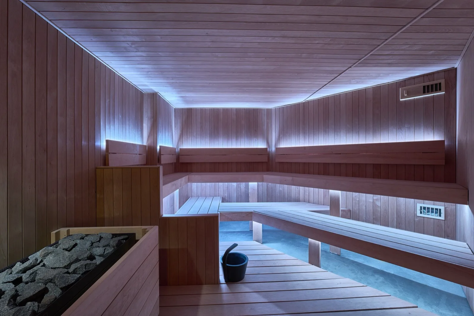 An empty Finnish dry-heat sauna in low warm light.